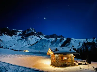 a cabin in the snow at night with a mountain at Suite Chalet Stella Margherita in Passo San Pellegrino