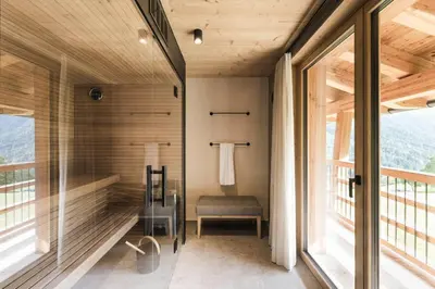 a room with a shower with a bench and windows at Florisa Mountain Chalet in Tires