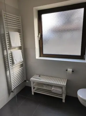 a bathroom with a window and a sink and a toilet at Apartment Kapplerhof in Lana