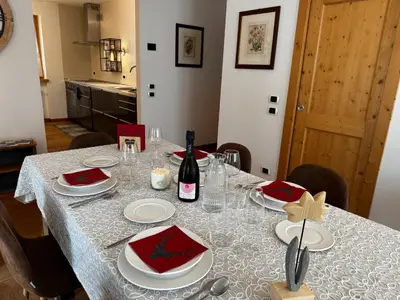 a dining room table with a bottle of wine on it at Appartamento La Finestra sul Pelmo in San Vito di Cadore