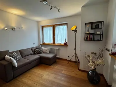 a living room with a couch and a window at Appartamento La Finestra sul Pelmo in San Vito di Cadore