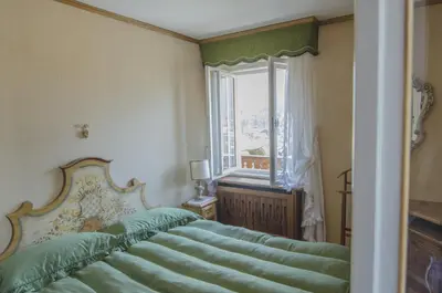 a bedroom with a green bed and a window at Casa Ronco in Cortina dʼAmpezzo