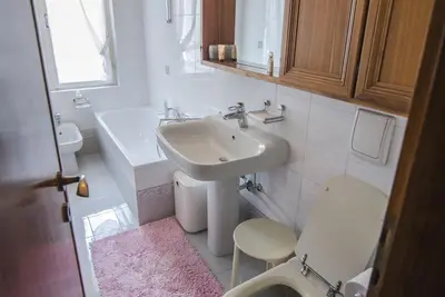 a white bathroom with a sink and a toilet at Casa Ronco in Cortina dʼAmpezzo