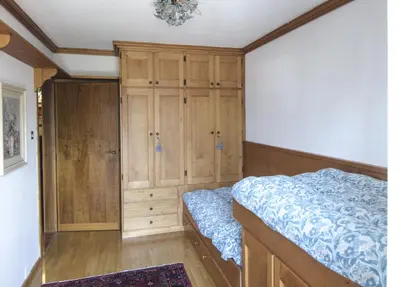 a bedroom with a bed and a wooden cabinet at Casa Ronco in Cortina dʼAmpezzo