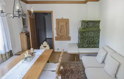 a living room with a table and a green cabinet at Casa Ronco in Cortina dʼAmpezzo