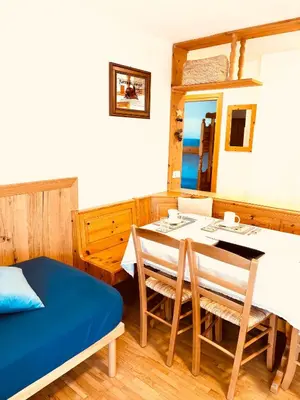 a dining room with a table and a bed at Apartment Fiemme Valley in Carano