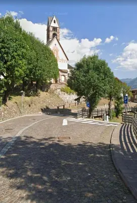 an empty road in front of a church at Apartment Fiemme Valley in Carano