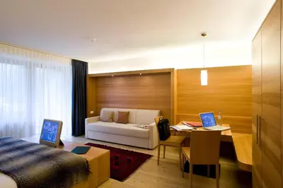 a bedroom with a bed with a wooden wall at Residence La Villa in La Villa