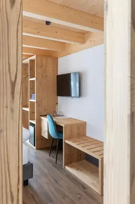 a room with a wooden desk and a blue chair at Fiemme in Vista in Ziano di Fiemme
