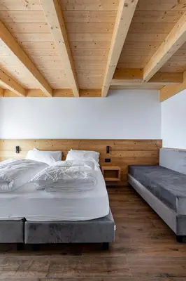 a bedroom with two beds and a wooden ceiling at Fiemme in Vista in Ziano di Fiemme