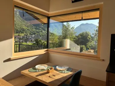 a table in a room with a large window at Fiemme in Vista in Ziano di Fiemme