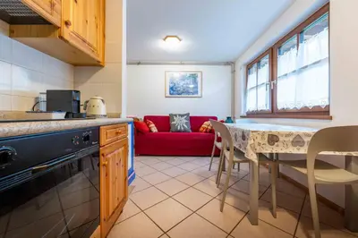 a kitchen and living room with a red couch at Cesa de Sass in Mazzin