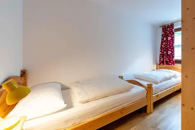 two beds in a room with a window at Cesa de Sass in Mazzin