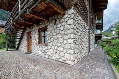 a stone building with a stone wall and a window at Cesa de Sass in Mazzin
