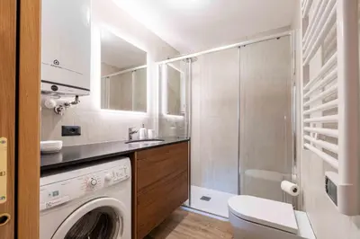 a bathroom with a washing machine and a shower at Cesa de Sass in Mazzin