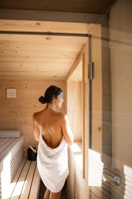 a woman is standing in a sauna at Essa Suites - NEW in Caldaro