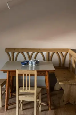 a wooden table and bench with a table and chairs at Essa Suites - NEW in Caldaro