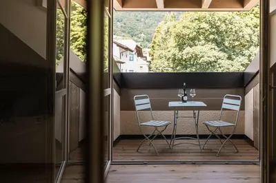a patio with a table and chairs on a balcony at Essa Suites - NEW in Caldaro