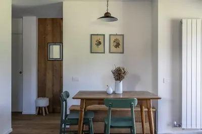 a dining room with a wooden table and green chairs at REMO 4 by WelcHome in San Vito di Cadore