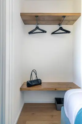 a bedroom with a wooden shelf next to a bed at REMO 4 by WelcHome in San Vito di Cadore