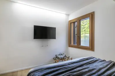 a bedroom with a bed and a television on the wall at REMO 4 by WelcHome in San Vito di Cadore