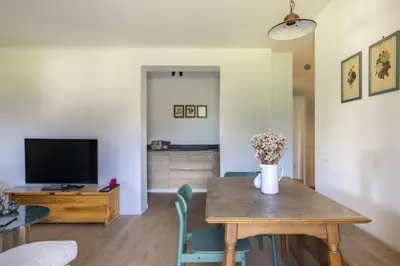 a living room with a table and a tv at REMO 4 by WelcHome in San Vito di Cadore