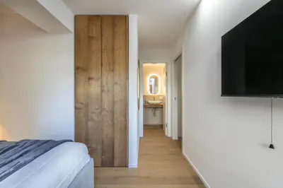 a bedroom with a bed and a flat screen tv at REMO 4 by WelcHome in San Vito di Cadore