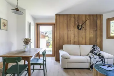 a living room with a white couch and a table at REMO 4 by WelcHome in San Vito di Cadore