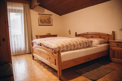 a bedroom with a wooden bed and a window at Farm apartment I neni in Lovara