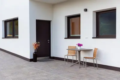 a table and chairs next to a door with windows at Langegger 1956 in Bolzano