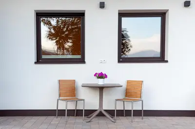 a table with two chairs and two windows at Langegger 1956 in Bolzano