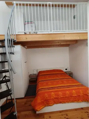 a bedroom with a bed with an orange blanket at Casanna in Cavareno
