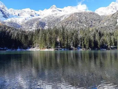 a view of a lake with snow covered mountains at Casanna in Cavareno