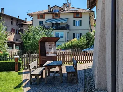 a bench and two chairs in front of a house at Casanna in Cavareno