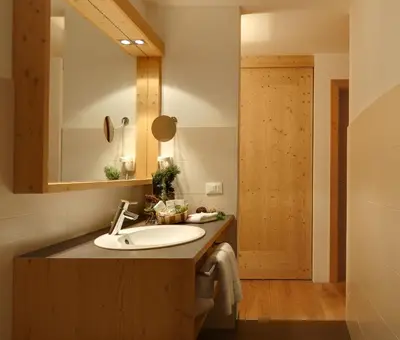 a bathroom with a sink and a mirror at Kräuterhotel Zischghof in Obereggen