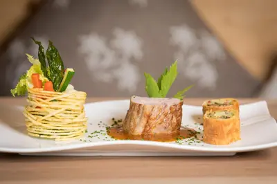 a plate of food with pasta and vegetables on a table at Kräuterhotel Zischghof in Obereggen