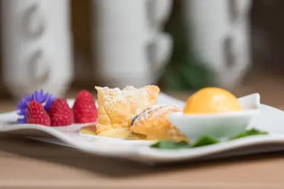 a plate of food with fruit on a table at Kräuterhotel Zischghof in Obereggen