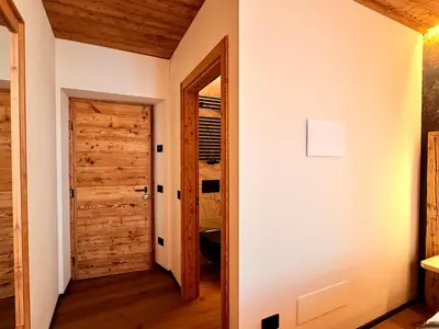 a hallway with a door leading to a closet at Il bosco di Fiemme in Predazzo