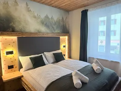 a bedroom with a large bed with towels on it at Il bosco di Fiemme in Predazzo