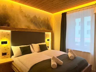 a bedroom with a large bed with slippers on it at Il bosco di Fiemme in Predazzo