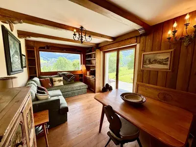 a living room with a table and a couch at Villa Anna apartment - Center view - in Cortina dʼAmpezzo
