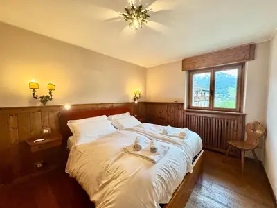 a bedroom with a bed with two dogs laying on it at Villa Anna apartment - Center view - in Cortina dʼAmpezzo