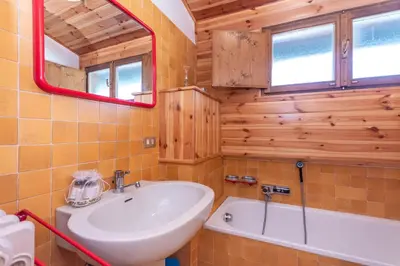 a bathroom with a sink and a tub and a mirror at Dolomite View Loft in Colle Santa Lucia