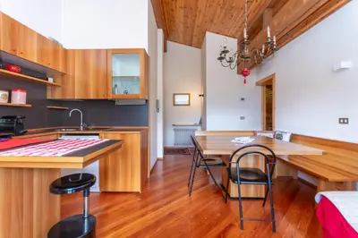 a kitchen and dining room with a table and chairs at Dolomite View Loft in Colle Santa Lucia