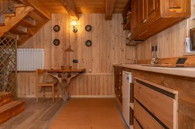 a kitchen with wooden walls and a wooden table at Tabia Sasso Bianco in Rocca Pietore