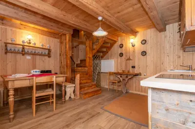 a kitchen and dining room in a log cabin at Tabia Sasso Bianco in Rocca Pietore