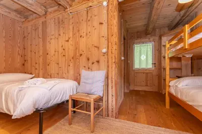 a log cabin bedroom with two beds and a ladder at Tabia Sasso Bianco in Rocca Pietore