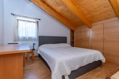 a bedroom with a bed and a desk in a room at Casa dei Gigli in Selva di Cadore