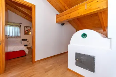 a room with a bedroom with a bed and a mirror at Casa dei Gigli in Selva di Cadore