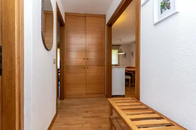 a hallway with a wooden door and a wooden bench at Casa dei Gigli in Selva di Cadore